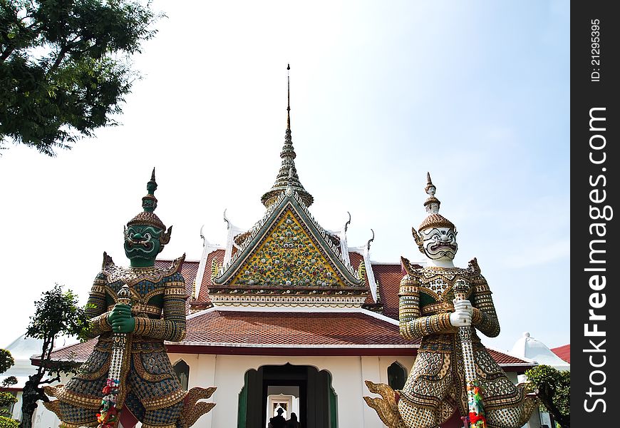 Double Giant Guard Statue at the Wat Arun (Temple of the Dawn) is a Buddhist temple (wat) in the Bangkok Yai district of Bangkok, Thailand with blue sky and River background . Double Giant Guard Statue at the Wat Arun (Temple of the Dawn) is a Buddhist temple (wat) in the Bangkok Yai district of Bangkok, Thailand with blue sky and River background .