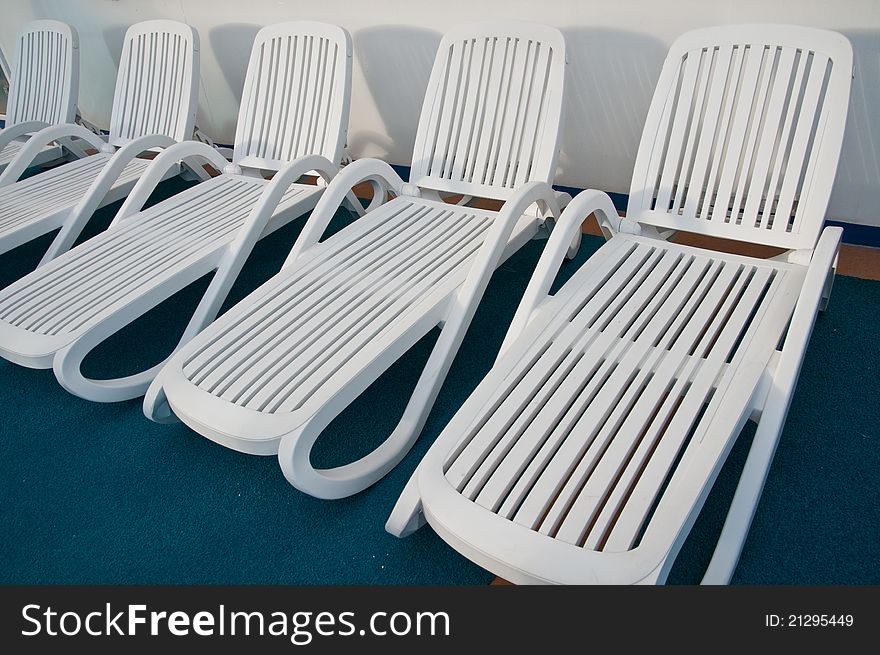 Several beach chairs used for sun tanning and relaxation.