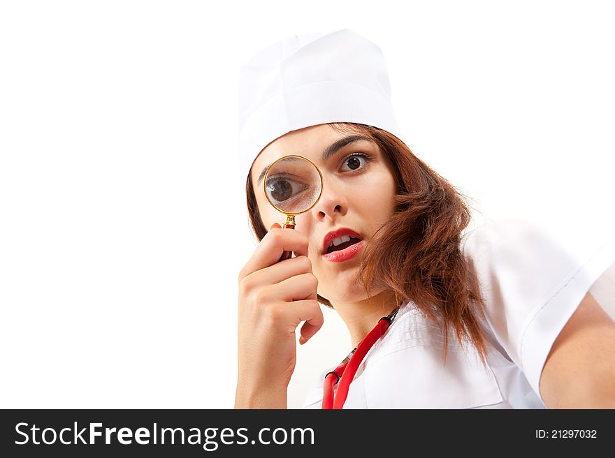 Surprised nurse doing a medical examination. She looks through a magnifying glass