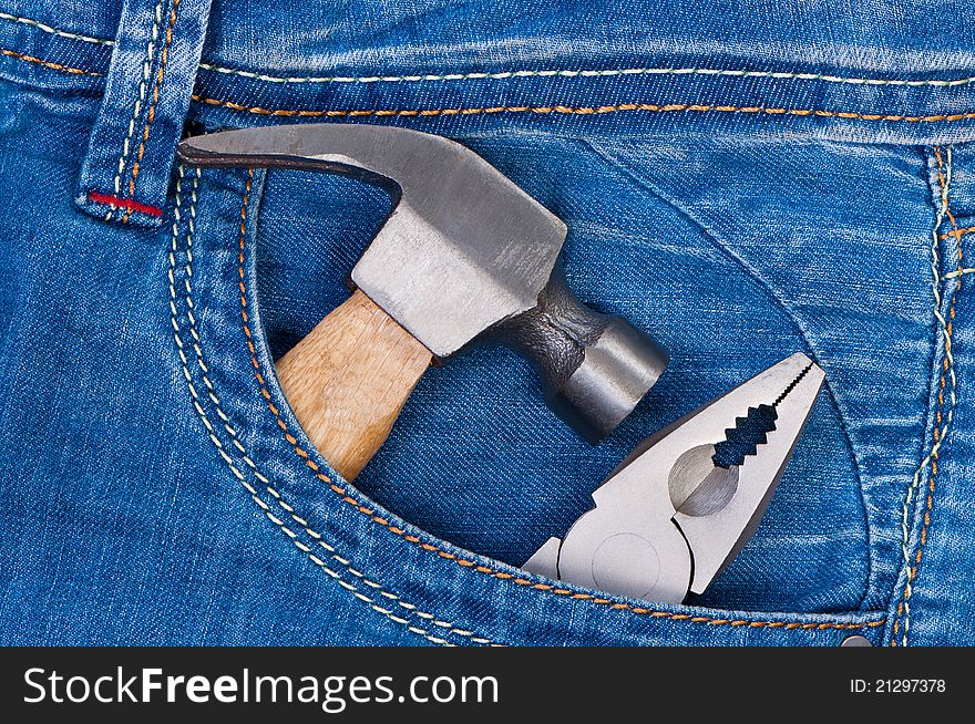 Hammer and pliers in pocket jeans. Concept of building and repairing.