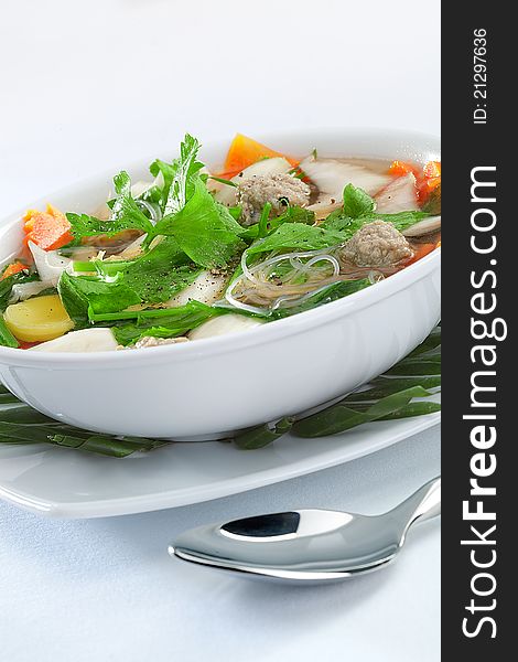 Close up view of nice soup with vegetables on white back. Close up view of nice soup with vegetables on white back