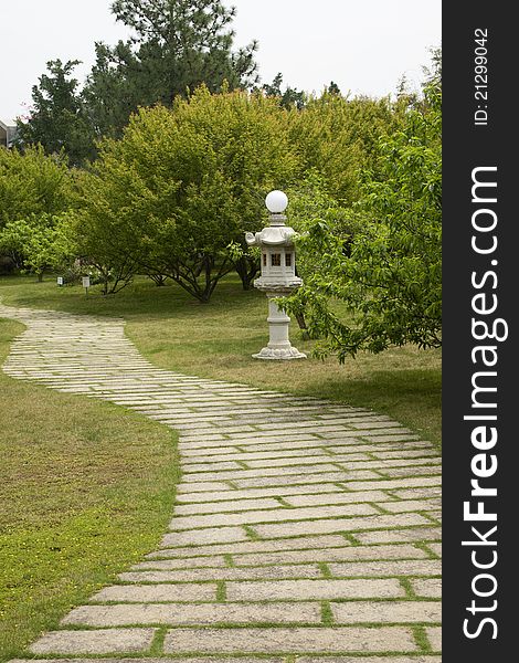 The stone path and sculpture in green tree. The stone path and sculpture in green tree