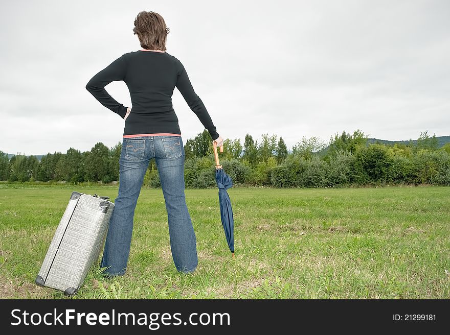 Woman On The Grass With Suitcase And Umbrella