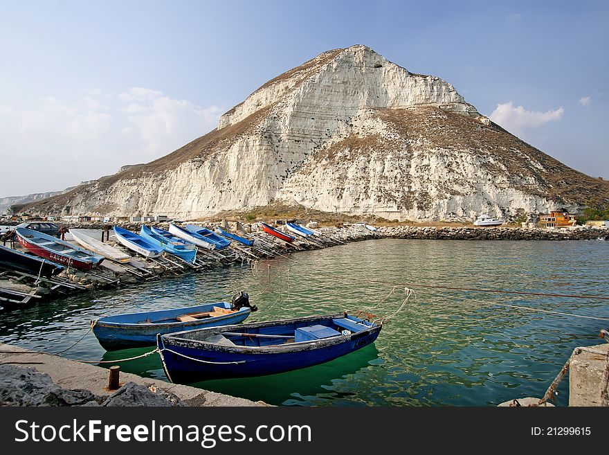 Two boats of fishermen are tied to the shore, many boats are on land. Two boats of fishermen are tied to the shore, many boats are on land.