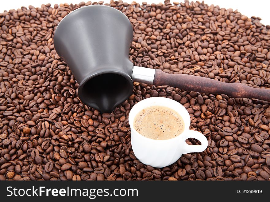 Coffee beans and cezve on white background