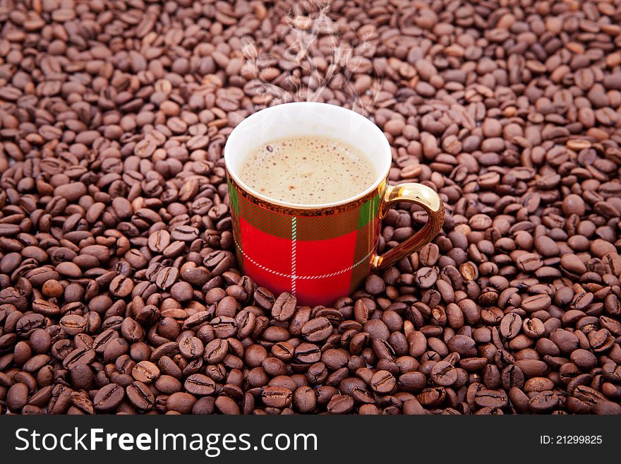 Cup of fresh coffee against coffee grains