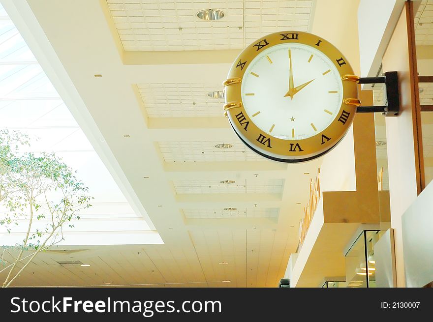 A gold clock inside a building. A gold clock inside a building