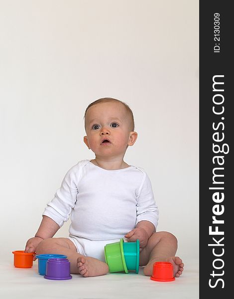 Image of adorable baby playing with stacking cups. Image of adorable baby playing with stacking cups