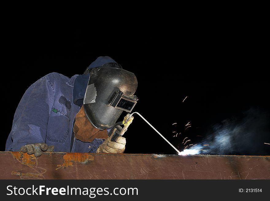 Welder working on steel at night. Welder working on steel at night