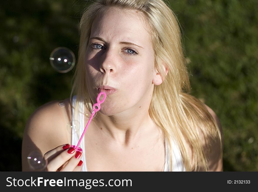 Girl Blowing bubbles at the camera.