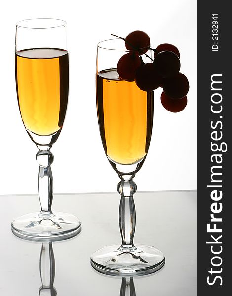 Glasses with white wine and grapevine on one of glasses. Glasses with white wine and grapevine on one of glasses