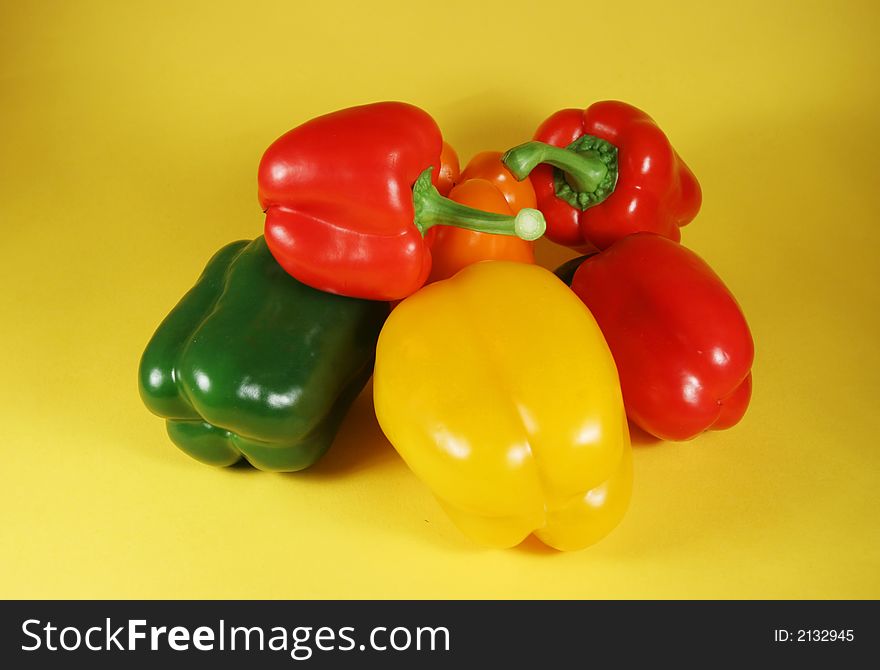 Group of the fresh bell peppers on yellow