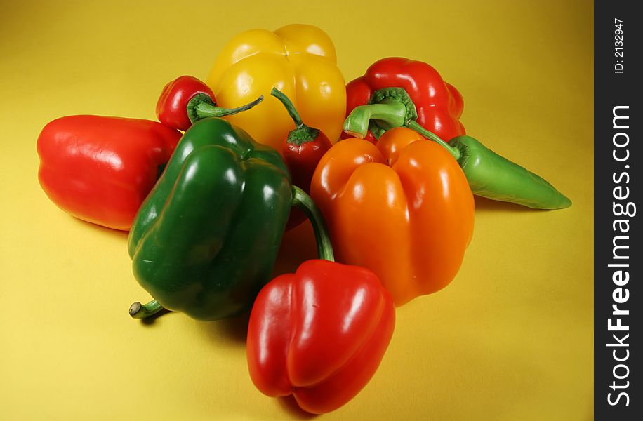 Group of the fresh bell peppers on yellow