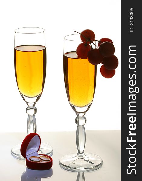 Two glasses with a champagne and wedding rings