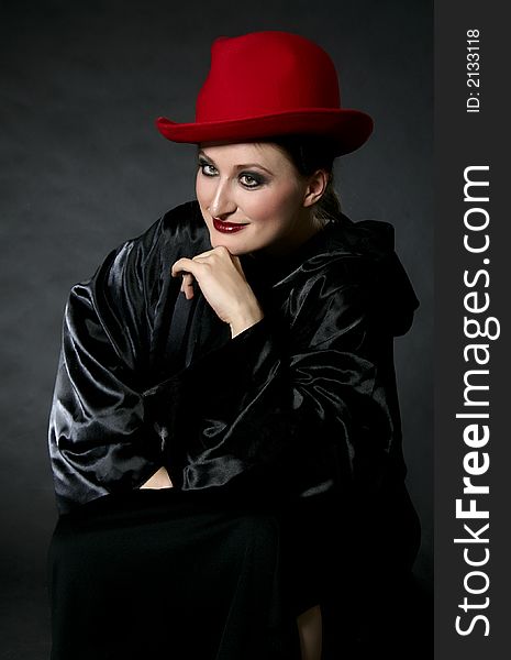 Sitting women in red hat: vintage, make-up.