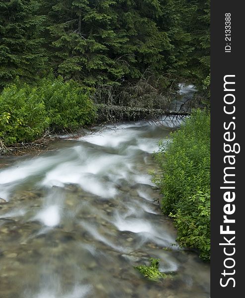 A stream or creek, is a body of water with a detectable current, confined within a bed and banks. A stream or creek, is a body of water with a detectable current, confined within a bed and banks.