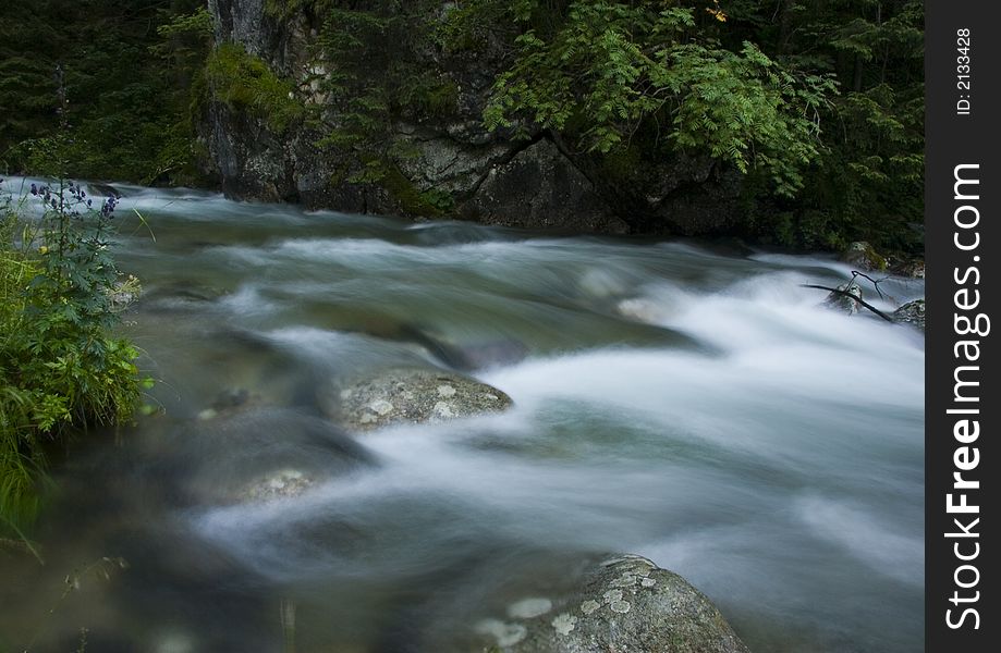 A stream or creek, is a body of water with a detectable current, confined within a bed and banks. A stream or creek, is a body of water with a detectable current, confined within a bed and banks.