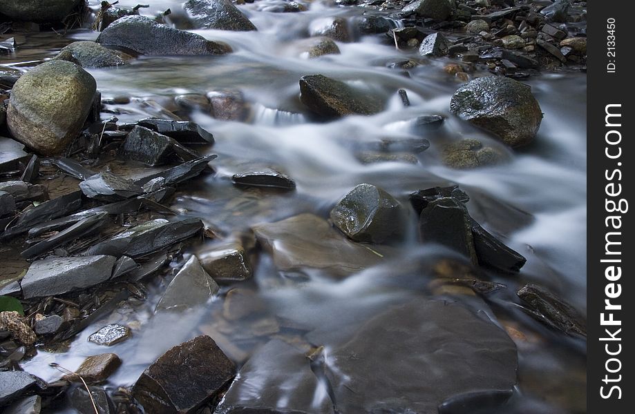 A stream or creek, is a body of water with a detectable current, confined within a bed and banks. A stream or creek, is a body of water with a detectable current, confined within a bed and banks.