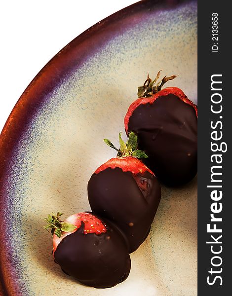 Chocolate covered strawberries on ceramic brown plate on white background. Chocolate covered strawberries on ceramic brown plate on white background