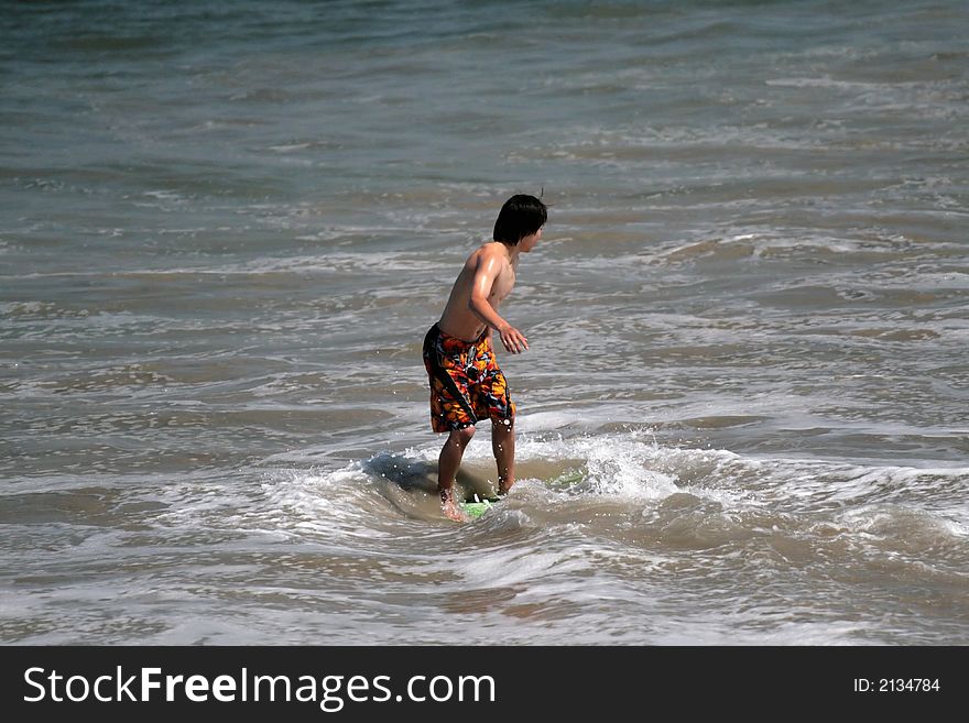 Young man boogie boarding in the Pacific