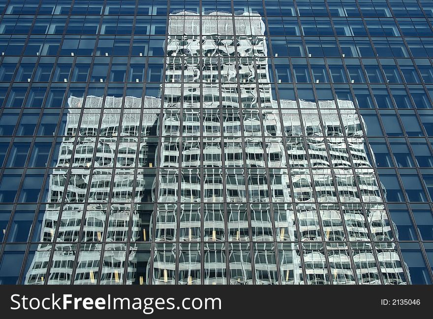 Skyscraper reflecting a white symmetrical office building. Skyscraper reflecting a white symmetrical office building.