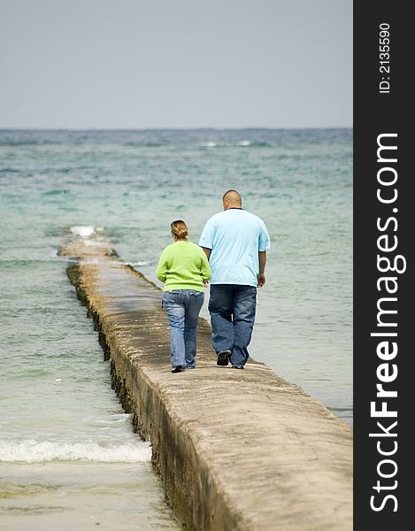 Couple walking hand and hand on a peer