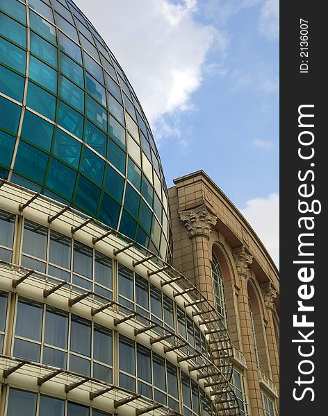 Modern glass office building with older building behind. Modern glass office building with older building behind