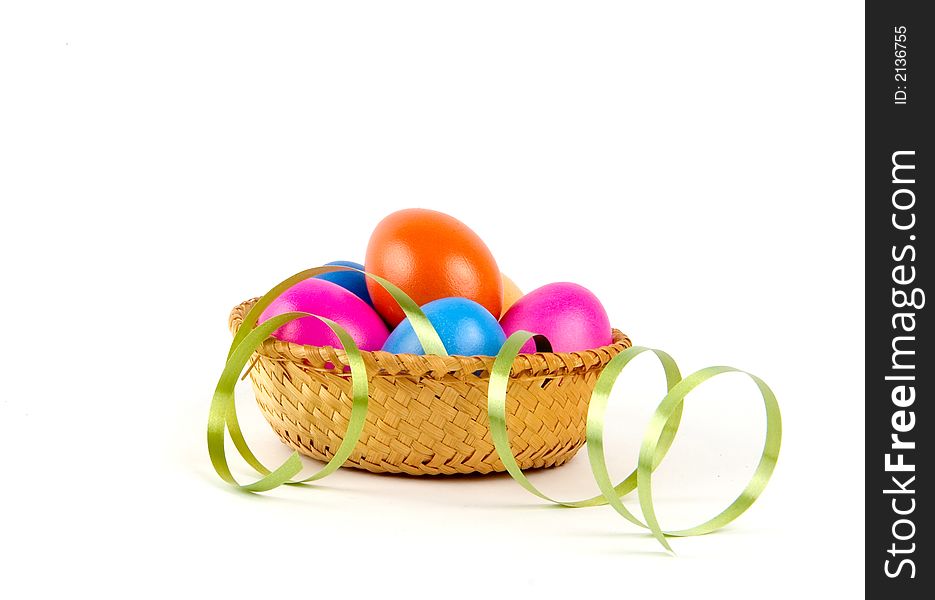 Color easter eggs in a small basket