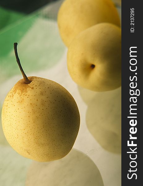 Three yellow Chinese pears on  green background