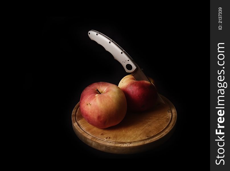 Two apple on a wood board with a silver knife. Two apple on a wood board with a silver knife