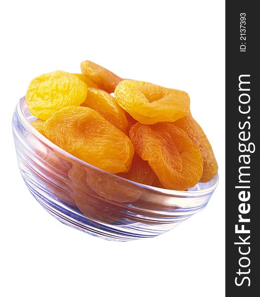 Large orange dried apricots in a glass transparent plate on a white background. Large orange dried apricots in a glass transparent plate on a white background