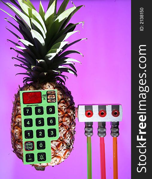 Pineapple with a keyboard and device to derivate the juice in three differently coloured pipes. Pineapple with a keyboard and device to derivate the juice in three differently coloured pipes