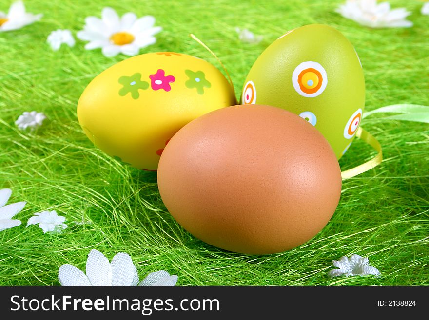 Closeup of several Easter eggs over green grass.