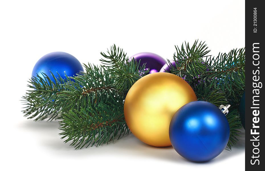 Christmas balls and green branch on white background