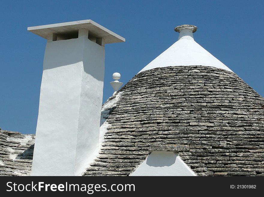 Typical conical roof and chemney of trullo in Alberobello, Italy during the summer. Typical conical roof and chemney of trullo in Alberobello, Italy during the summer