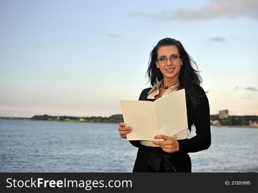 Girl holding blank paper. sea on the background