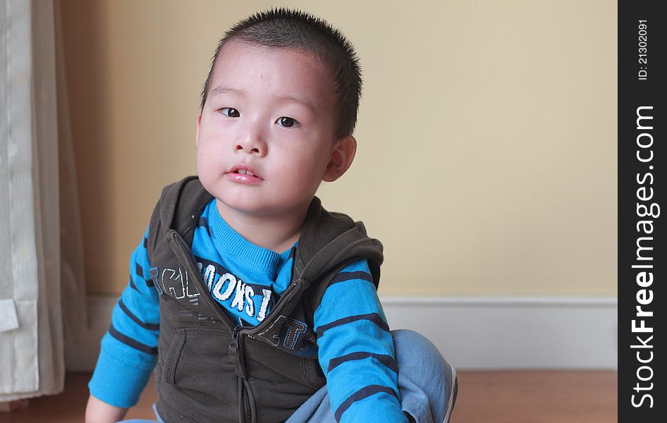 Cute chinese kid sit on floor indoor. Cute chinese kid sit on floor indoor