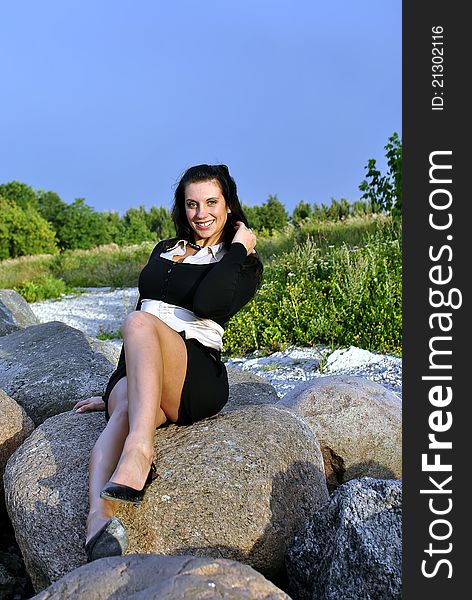 Girl sitting on rocks and smiling