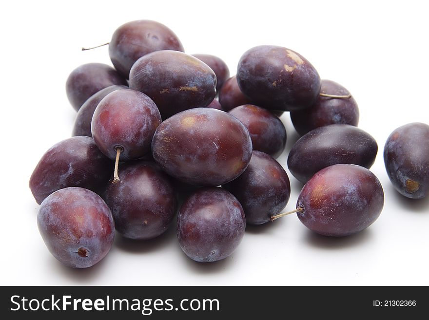 Plums with stem on white background