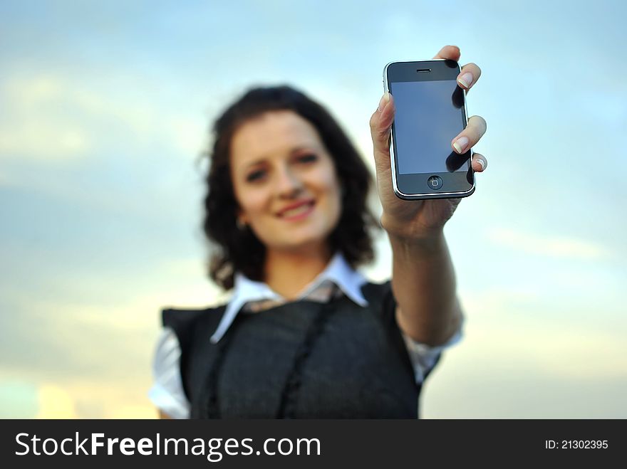 Lovely young woman showing mobile phone. focused on the phone.