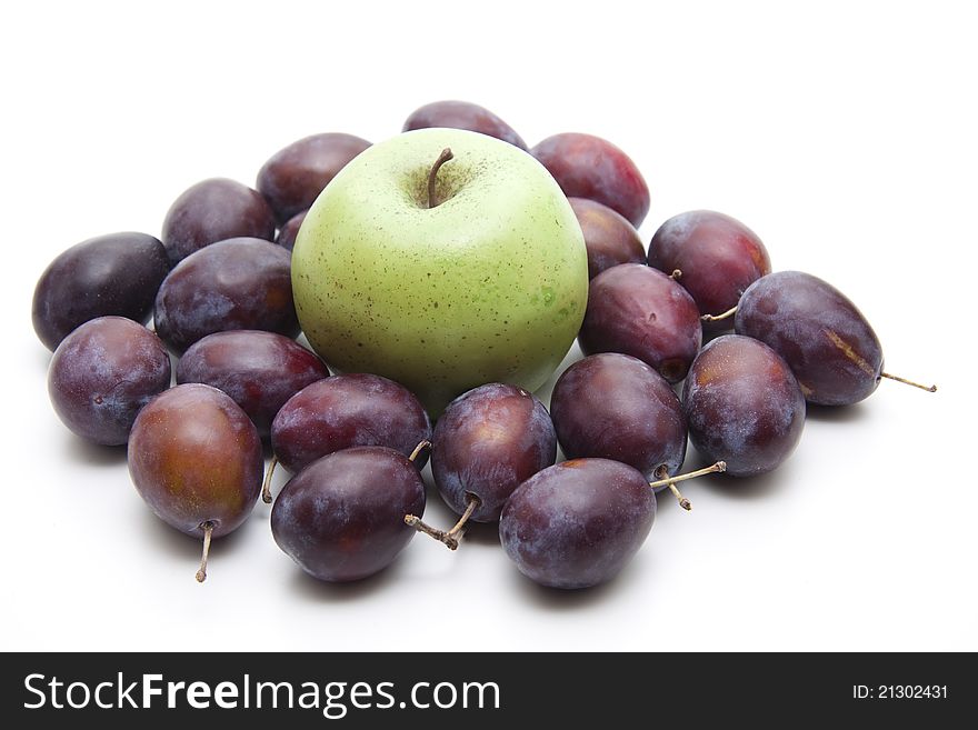 Plums with apple on white background