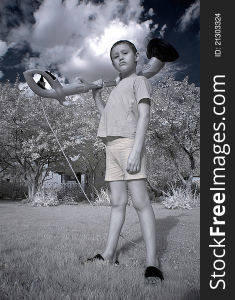 Young boy with trimmer in garden