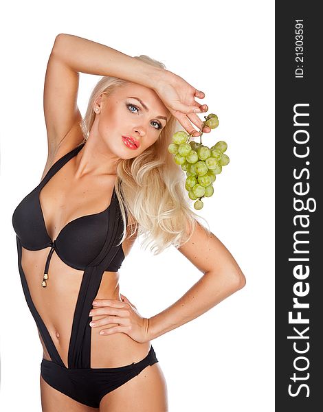 Blonde in black bathing suit eating grapes. Blonde in black bathing suit eating grapes