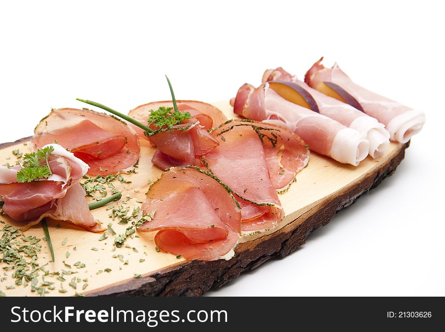 Ham on wooden board with herbs