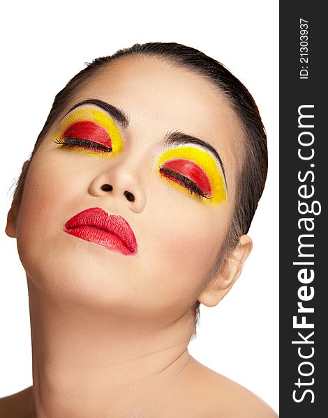 Close up of an Asian female's face wearing red and yellow makeup. Close up of an Asian female's face wearing red and yellow makeup