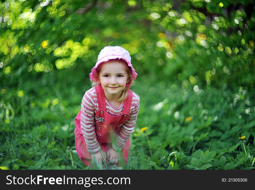 Playful little girl in hat on grass. may day