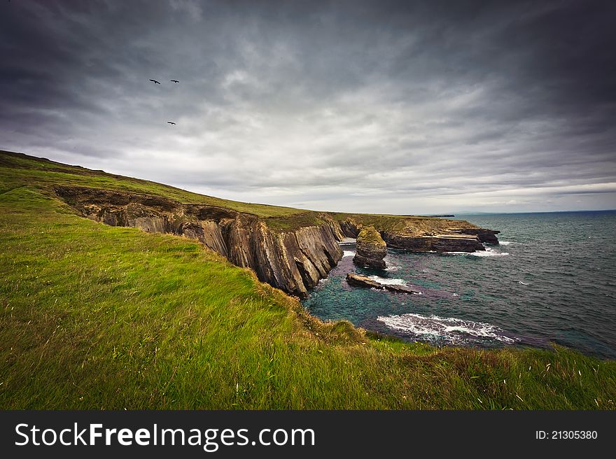 Cliffs by the sea under cloudy sky, Loop Head, Co. Clare, Ireland. Cliffs by the sea under cloudy sky, Loop Head, Co. Clare, Ireland