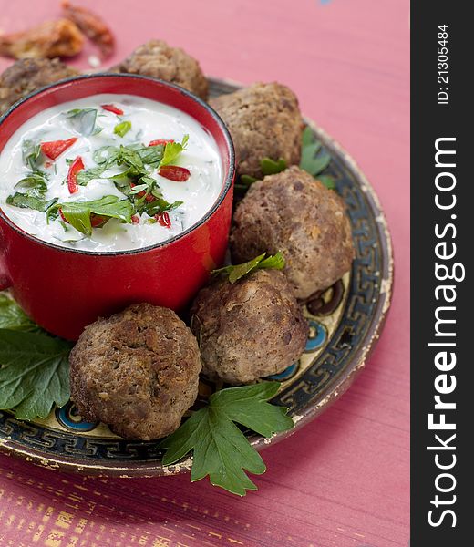 Minced meat ball with tzatziki sauce on plate. Selective focus