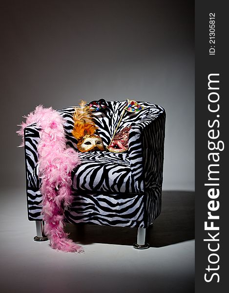 Image shoeing brightly coloured masquerade masks on retro style chair. Image shoeing brightly coloured masquerade masks on retro style chair