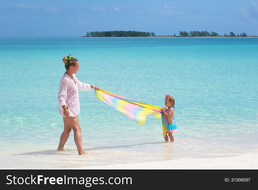 A young mother is playing with her baby girl on the beach. A young mother is playing with her baby girl on the beach